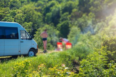 Pitoresk bir yerde kamp. Yakınlarda park halindeki bir araba var.
