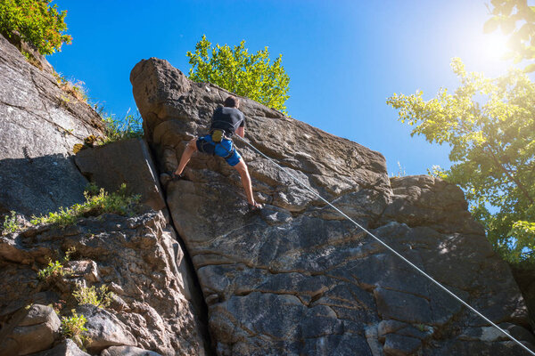 Rock climbing. A man climbs to the top of a cliff