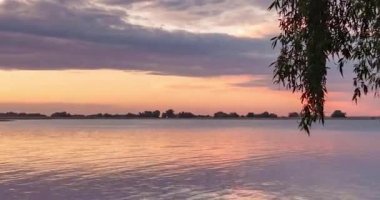 Nehirde kırmızı tonların renkli gün batımı. Zaman Atlamalı