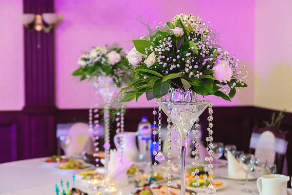 Arranjo de flores para decorar uma mesa de banquete um fundo roxo — Fotografia de Stock