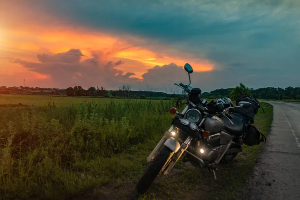 Motocicleta retro se encuentra en la carretera al atardecer fondo . — Foto de Stock