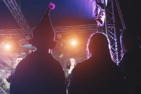 おかしな帽子をかぶった男がステージ近くのコンサートに立つ — ストック写真