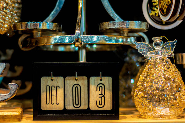 The inscription 3 December on wooden calendar cubes on the background of New Year's decorations