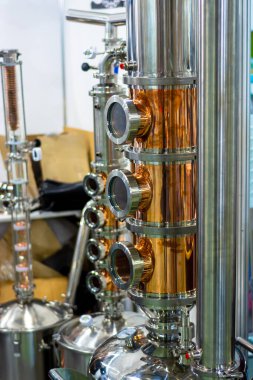 Parlak paslanmaz çelik ve bakır borular. Evde votka yapmak için bir cihaz.