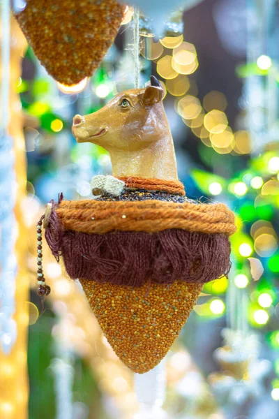 Toy bull head hanging on a christmas tree.Shallow depth of field