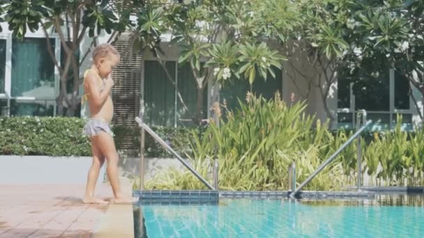 Lilla flickan kommer till poolen och hoppa i vattnet i slow motion — Stockvideo