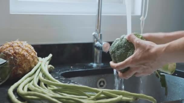 Close-up mulheres mãos lavar brócolis na cozinha doméstica — Vídeo de Stock