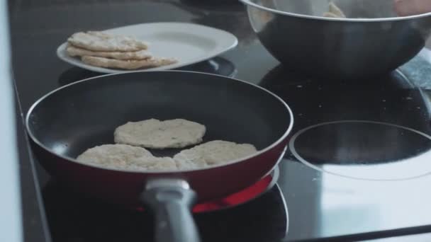 Giovane donna che cucina focaccine fatte in casa sulla padella in cucina domestica — Video Stock