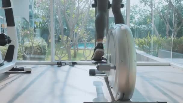 Pieds féminins à vélo stationnaire à la salle de gym — Video