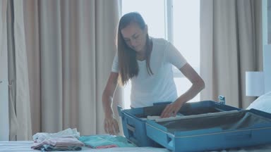 Genç küçük kızıyla birlikte bir bavul toplama.