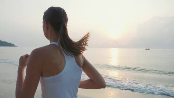 Steadicam disparo de joven atractiva mujer corriendo en la playa al amanecer — Vídeos de Stock