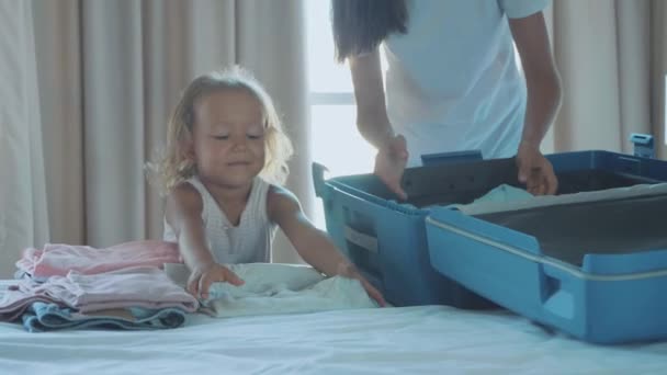 Giovane con la piccola figlia che raccoglie una valigia insieme . — Video Stock