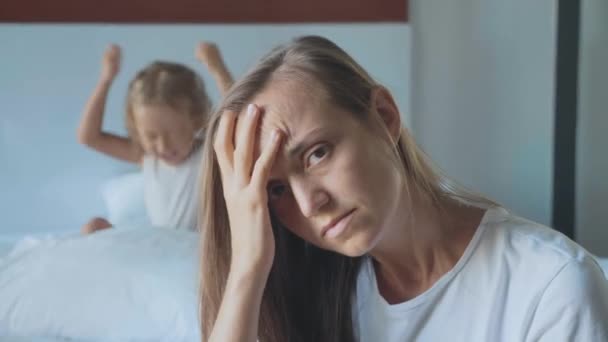 Αναστατωμένος μητέρα με θυμωμένος μικρό παιδί που ουρλιάζει μαξιλάρι στο φόντο — Αρχείο Βίντεο