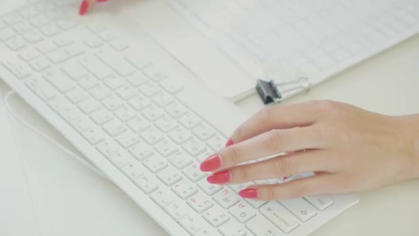 Primer plano de la mano de la mujer escribiendo en el teclado de la computadora en la oficina moderna — Vídeos de Stock