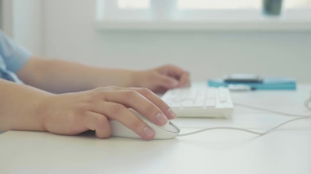 Мужская рука с компьютерной мышью за рабочим столом, человек работает на настольном компьютере — стоковое видео