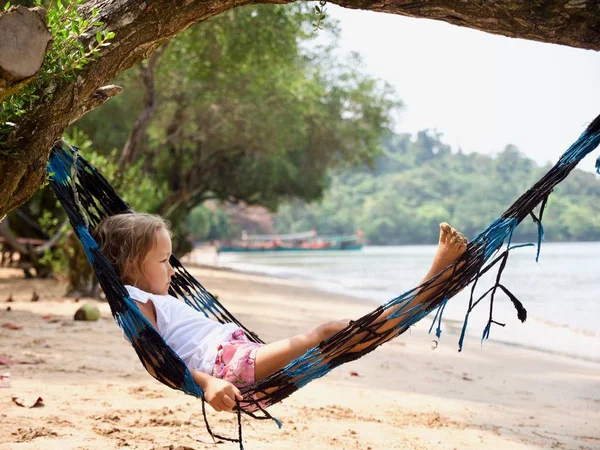 Linda niña acostada en la hamaca y relajarse en la playa de arena — Foto de Stock