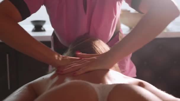 Massage concept. Mooie jonge vrouw reciving relxing massage in de spa salon — Stockvideo