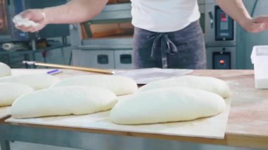 Profesyonel baker fırın mutfak pişirme önce çiğ ekmek bir un dökme