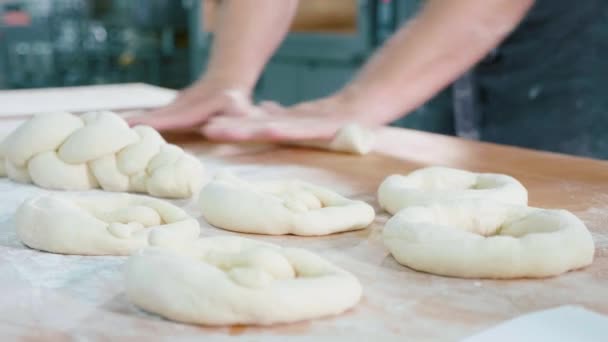 Professional baker is forming pieces of dough in bakery commercial kitchen. — Stock Video