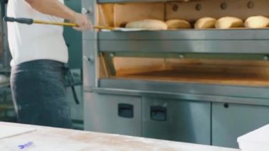 Ticari mutfak fırında içine çiğ ekmek profesyonel baker koyar