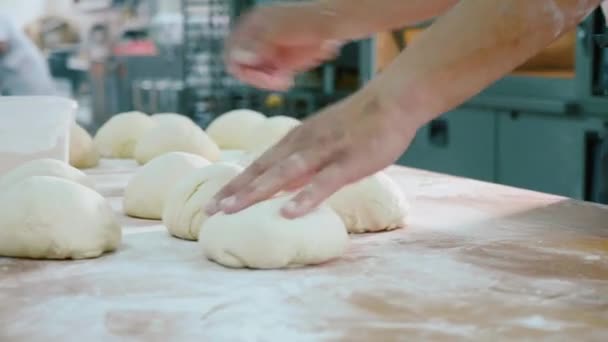Професійний пекар формує шматки тіста на хлібопекарській комерційній кухні . — стокове відео