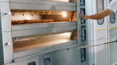 Profesyonel baker bir ticari mutfak fırında ekmek alarak