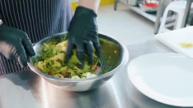 Profesyonel şef tarafından el çelik kase salata karıştırma.