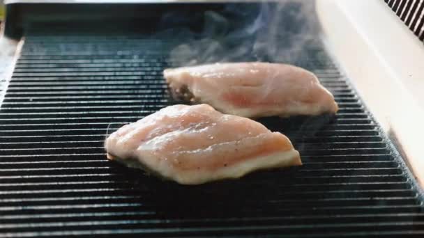 Μια μπριζόλα από φρέσκα ψάρια είναι τηγανισμένα σε μια καυτή σχάρα με άρωμα και τον καπνό — Αρχείο Βίντεο