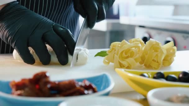 Chef-kok snijden mozzarella kaas op restaurant keuken. — Stockvideo