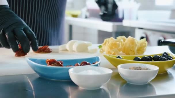 Szef kuchni cięcia suszonych pomidorów za przygotowanie kuchni włoskiej — Wideo stockowe