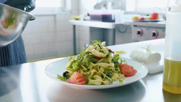 Chef profissional coloca salada na placa à mão de tigela de aço . — Vídeo de Stock