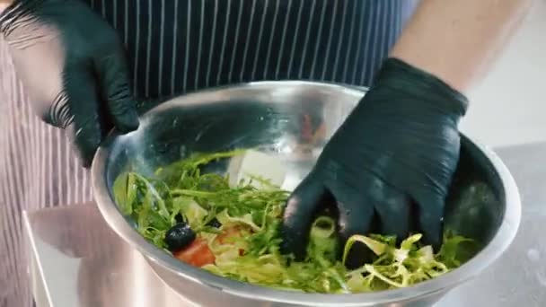 Chef profissional misturando salada à mão em tigela de aço . — Vídeo de Stock