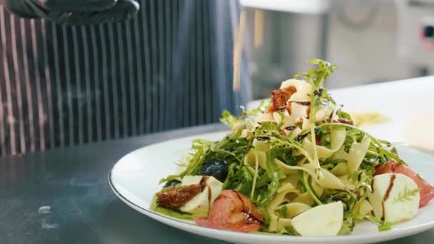 Chef professionale spruzza con anacardi un'insalata fresca . — Video Stock