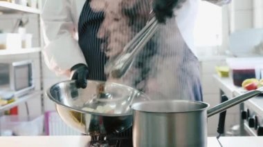 Ticari mutfak maşa ile kaynar bir İtalyan pasta alarak Şef.
