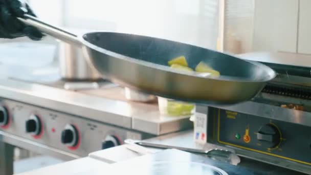 Profi-Koch rührt und wirft eine gehackte Kartoffel in der Pfanne, Nahaufnahme — Stockvideo