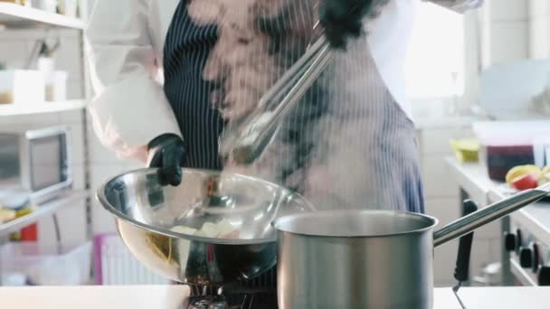 Шеф-повар берет кипящую итальянскую пасту с щипцами на коммерческой кухне . — стоковое видео
