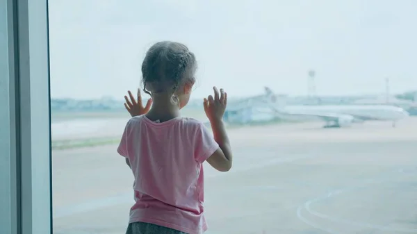 Little child girl looks out of window on airplane, rear wiew. — Stock Photo, Image