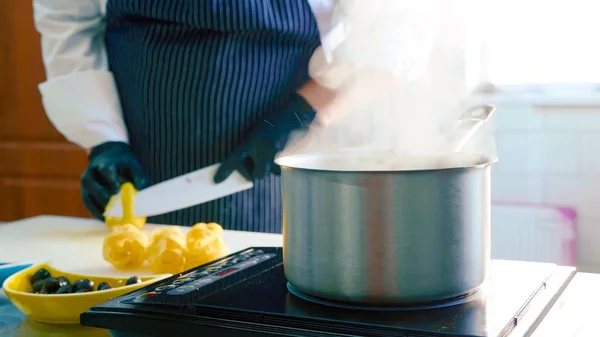 Primer plano de una cacerola humeante en una estufa cuando el chef limpia un limón —  Fotos de Stock