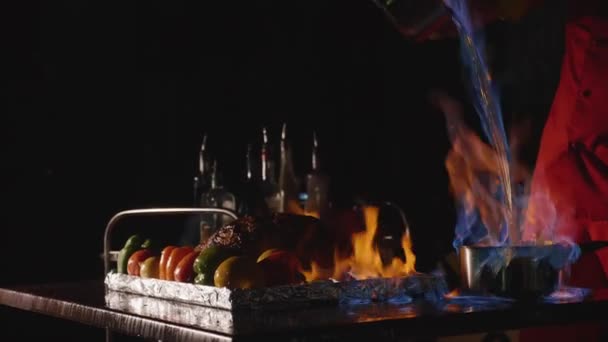 Gros plan sur la cuisine du chef un plat de banquet principal. Légumes et viande avec feu spectacle — Video