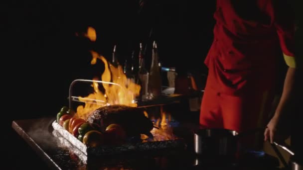 Close-up of chef cooking a main banquet dish. Vegetables and meat with fire show — Stock Video