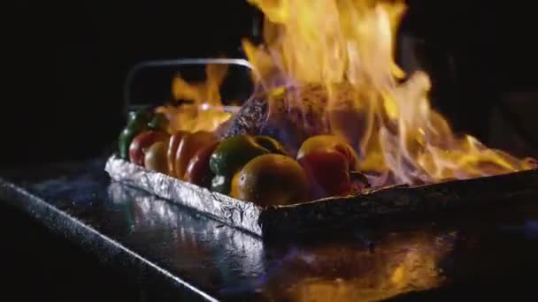 Zbliżenie: kucharz, gotowanie danie główne bankiet. Warzywa i mięso z fire show — Wideo stockowe