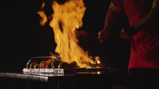 Крупним планом шеф-кухар готує основну банкетну страву. Овочі та м'ясо з вогнем шоу — стокове відео