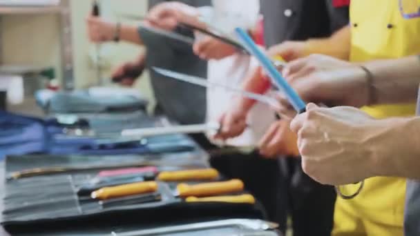 Un gruppo di chef affila i coltelli. Cookers si prepara per la classe di padrone — Video Stock