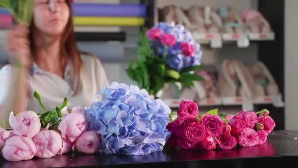Florista chica hace un ramo en un salón de flores, primer plano — Vídeo de stock