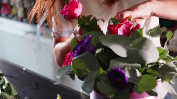 Floristería chica hace una caja floral en un salón de flores, primer plano — Vídeo de stock