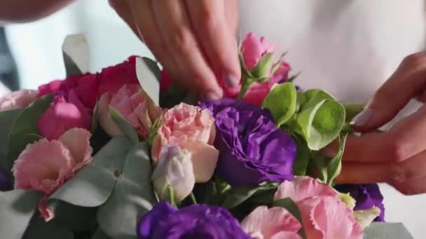 Fiorista ragazza fa una scatola floreale in un salone di fiori, primo piano — Video Stock