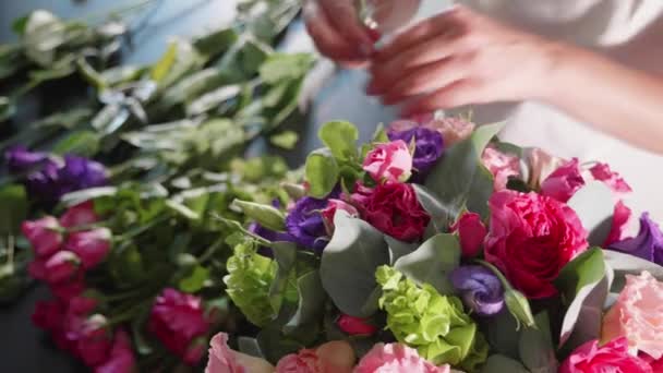 Menina florista faz uma caixa floral em um salão de flores, close-up — Vídeo de Stock