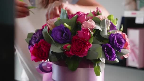 Bloemist meisje maakt een floral doos in de salon van een bloem, close-up — Stockvideo