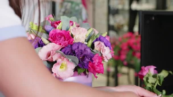 Цветочница делает цветочную коробку в цветочном салоне, крупным планом — стоковое видео