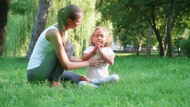 年轻的运动母亲教练她的小可爱的女儿做瑜伽练习 — 图库视频影像